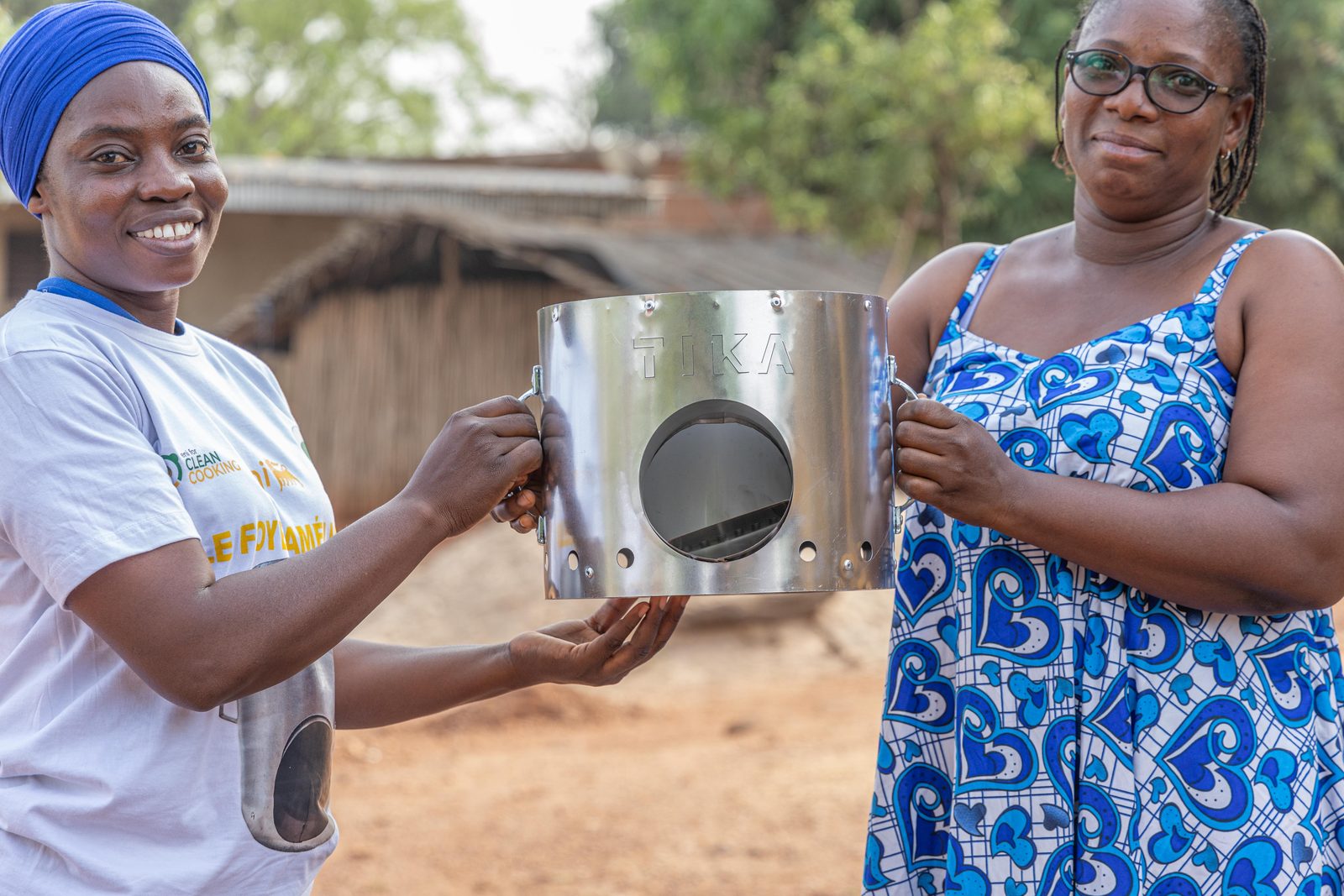 Remise d'un foyer amélioré entre une animatrice souriante et une bénéficiaire