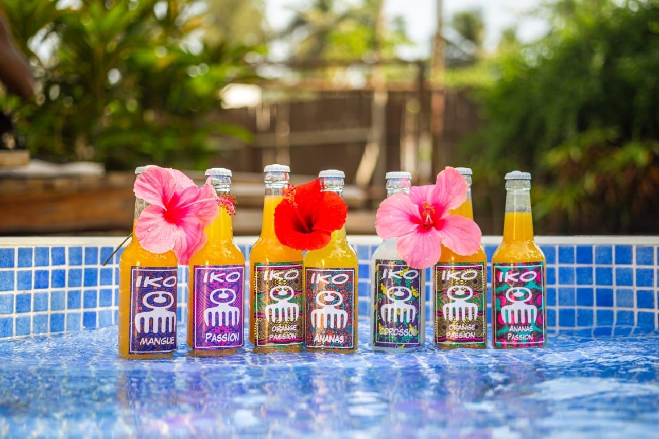Bouteilles de jus et hibiscus alignées au bord d'une piscine